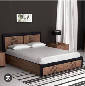 a bedroom with a large bed with a wooden headboard at Pujara Hotel in Diggi