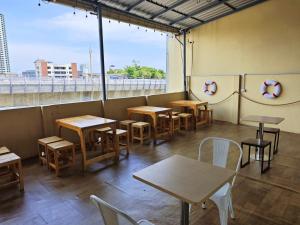 a restaurant with tables and chairs and a large window at latitude 13 Room & breakfast in Bangkok