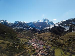 una vista aérea de un pueblo en un valle de montaña en El Hayedo de Argovejo, en Argovejo 8 fotos más