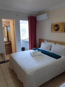 a bedroom with a large white bed with towels on it at Flat Rio Quente 110-A in Rio Quente