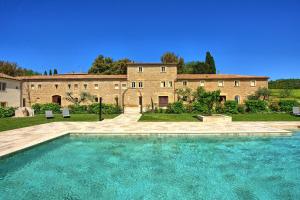 a large house with a swimming pool in front of a building at Borgo Ariano near Volterra by PosarelliVillas in SantʼAnastasio