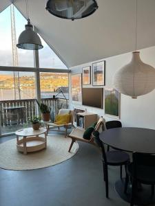 a living room with couches and a table and chairs at Charming Apartment in Strendur Faroe Islands, with Stunning Seaview in Strendur +12 photos