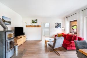 インツェルにあるHaus Katharina 1の赤いソファとテレビのあるリビングルーム