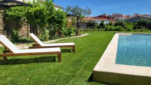 a yard with two lounge chairs and a swimming pool at La casa nido in Torrejón el Rubio
