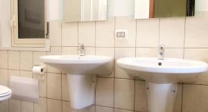 bagno con 2 lavandini e specchio di Hotel Marconi a Pietraperzia