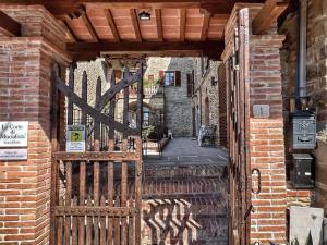 an entrance to a brick building with a wooden gate at La Corte di Muciafora in Borgo a Giovi