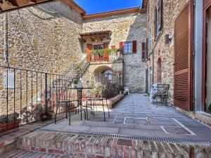 a patio with a table and chairs next to a building at La Corte di Muciafora in Borgo a Giovi