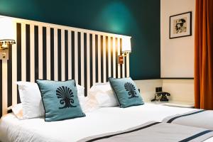 a bedroom with a bed with blue pillows with faces at Napoleon in Ajaccio