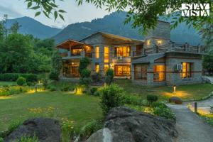 a large house with a large yard in front of it at StayVista at Moets Waterfront Estate by the Riverside - 3BR with BBQ, Bonfire and Lawn in Manāli