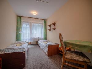 a room with two beds and a desk and a window at Ośrodek Szpulki in Zakopane
