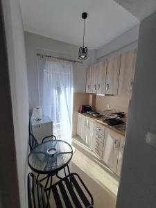 a small kitchen with a glass table and chairs at Eleni's seaside home in Asprovalta +13 photos