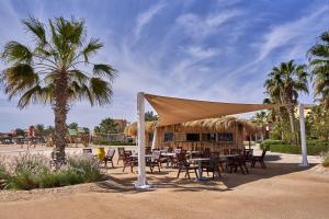 a restaurant with tables and chairs under a tent at Mosaique Hotel El Gouna in Hurghada +36 photos