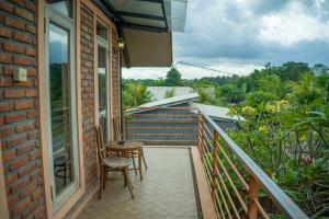 a balcony with a table and chairs on a building at Uma Dewa homestay in Keramas