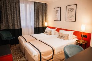 a hotel room with two beds and two chairs at Napoleon in Ajaccio