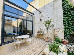 a patio with a table and chairs on a wooden deck at Au bon accueil in Badens +8 photos