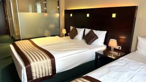 Postel nebo postele na pokoji v ubytování Hotel Lumière an der Messe