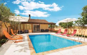 a swimming pool with chairs and umbrellas next to a house at Mario and Maria in Vodnjan