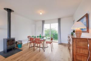 a dining room with a table and chairs and a fireplace at Vue mer - Maison pour 6 avec balcon - Jardin in Plouguerneau