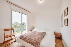 a white bedroom with a bed and a window at Vue mer - Maison pour 6 avec balcon - Jardin in Plouguerneau