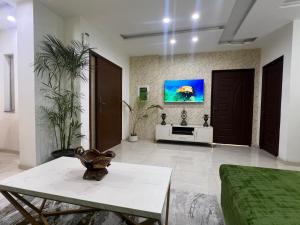 a living room with a tv on the wall at Royal BNB Two BedRoom Luxury Apartment in Lahore