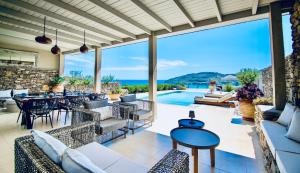 an outdoor patio with tables and chairs and a pool at VLK: Villa Lindos Kalliopi, Rhodes in Líndos