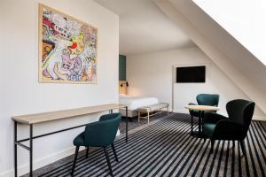 a hotel room with a bed and chairs at Radisson Hotel Brussels Centre Midi in Brussels