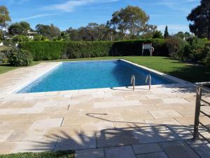 a swimming pool in a yard with a patio at Casa do lago em Sol Tróia in Troia