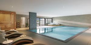 a large swimming pool in a room with chairs at TERRESENS - Les Sources de Canopée in Saint-Gervais-les-Bains