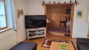 a living room with a flat screen tv on a stand at Haus Sonnengarten in Siegsdorf