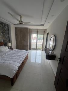 a bedroom with a bed and a ceiling fan at Royal BNB Two BedRoom Luxury Apartment in Lahore