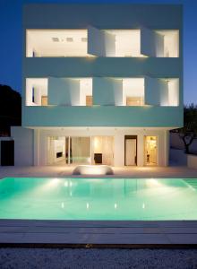 una grande casa bianca con una piscina di fronte di Infinity White Complex a Porto Rafti