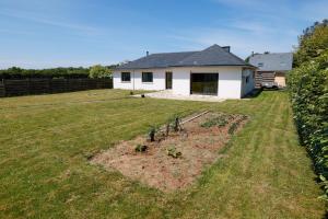 a yard with a house in the background at Grande maison familiale proche gr34 in Garlan