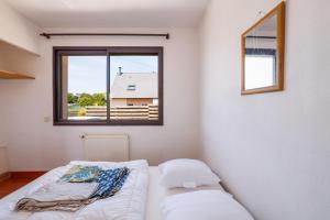 a white room with a bed and a window at Grande maison familiale proche gr34 in Garlan