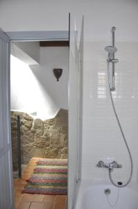 y baño con ducha y pared de piedra. en Cassa Dulce, en Vejer de la Frontera