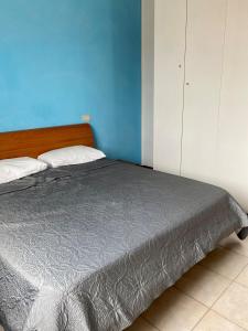 a bed in a bedroom with a blue wall at Appartamento 550 mt dal mare in Punta Marina +4 photos