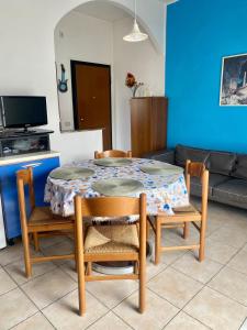 a dining room table with two chairs and a couch at Appartamento 550 mt dal mare in Punta Marina