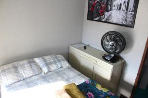 a bedroom with a bed and a fan on the wall at Pousada Captain Morgan Pontal do Sul com Piscina in Pontal do Paraná