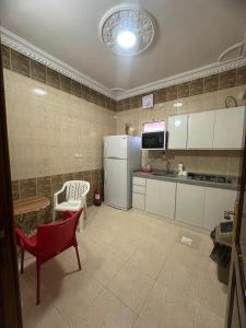 a kitchen with a refrigerator and a table and a chair at مساكن المدينة المنورة in Medina