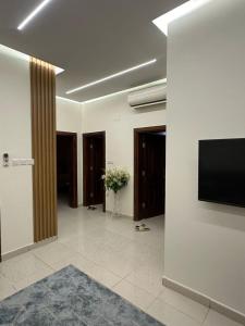 a room with a tv on a wall and a hallway at مساكن المدينة المنورة in Medina +14 photos