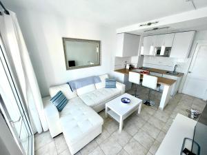 a living room with a white couch and a table at Relaxing upper floor Apartment- exclusive complex. in Los Pocillos