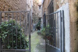 an entrance to an alley with an iron gate at La suite Galerie d'ART in Céret