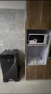 a small kitchen with a microwave and a counter at Royal BNB Two BedRoom Luxury Apartment in Lahore +4 photos