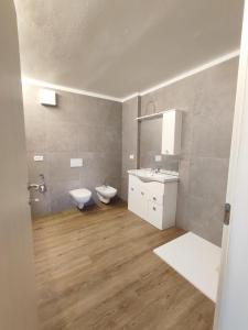 a bathroom with a toilet and a sink and a mirror at Erica in Folgaria +83 photos