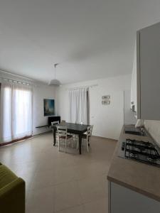 a kitchen and a dining room with a table and a kitchen and a living room at Villa Althea in Piombino