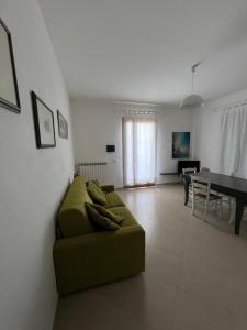 a living room with a green couch and a table at Villa Althea in Piombino