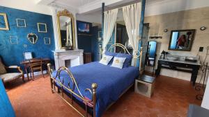 a bedroom with a blue bed and a desk at Le N 9 in Argeliers