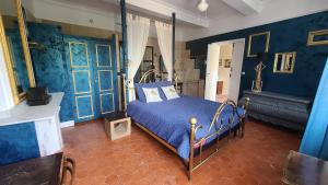 a bedroom with blue walls and a bed with blue sheets at Le N 9 in Argeliers