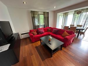 a living room with a red couch and a table at Zámek Žinkovy in Žinkovy