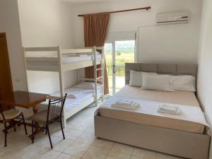 a bedroom with a bed and a desk and a bunk bed at Apartments Rudi in Orikum