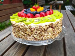 a cake with fruit on top on a wooden table at Albertsgårdens Bed & Breakfast i Norra Häljaröd in Farhult